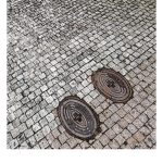 Zwei in das Straßenpflaster eingelassene Deckel von Hydranten